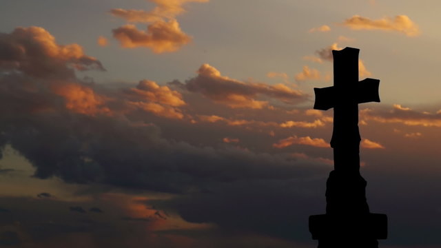Time lapse of stone cross with gorgeous sunset clouds