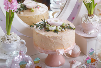 Dessert table for a party. Ombre cake, cupcakes, sweetness and flowers