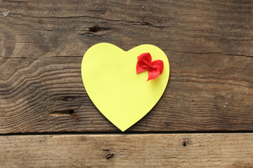 Paper heart with bow on wooden background and copy space