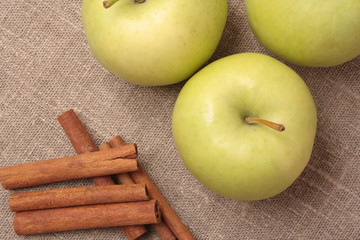 Ripe green apple with cinnamon sticks