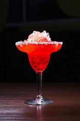 A cocktail with ice in a glass on a dark background