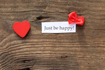 Just be happy message with bow and heart on wooden background