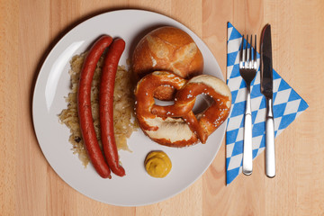 Debreziner auf Sauerkraut mit Semmel und Breze von oben