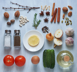 Set of spices, vegetables and herbs on a light wooden background