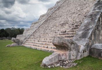 Chichen Itza pyramid stairs with snake head under a storm, Mexic