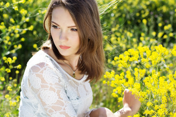Naklejka premium Beautiful girl in field with yellow flowers