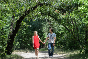 Fototapeta na wymiar young pretty couple in the green summer park
