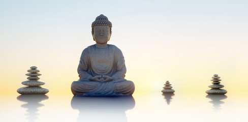 Buddhastatue und Steintürme im Sonnenuntergang