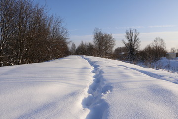 Fototapeta na wymiar Тропинка в снегу зимним солнечным днем