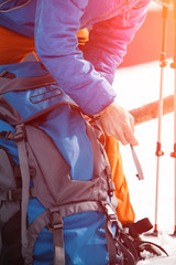 Hiker packing backpack closeup on mountain snow