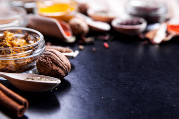 Spices on black background in special jars. Food