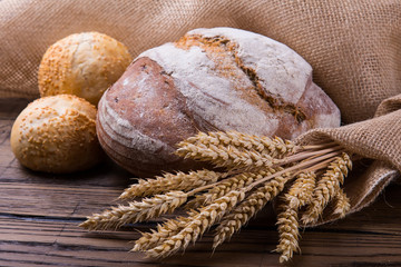 Assortment of baked bread on wooden table background