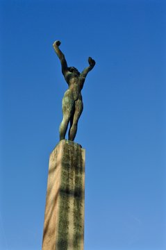 Statue aus Bronze auf der Landiwiese, Stadt Zürich:  Frau streckt Arme zum blauen Himmel. Titel:  Mädchen mit erhobenen Händen, Bildhauer: Hermann Haller, (1880-1950) - Hochformat