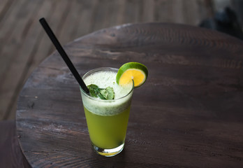 Fresh homemade lemonade with mint on dark wooden table in cafe