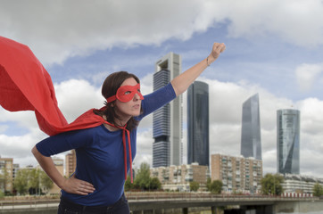 Fototapeta na wymiar Super woman hero with red cape and mask in Madrid.