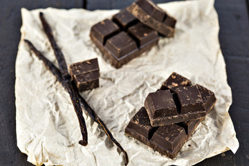 Chunks of dark chocolate bar and vanilla beans