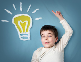seven years old boy and a bulb near. Child with an idea