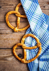 Homemade pastries. Pretzel with kitchen towel on wooden background. Food