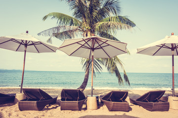 Fototapeta na wymiar Umbrella and chair on the tropical beautiful beach