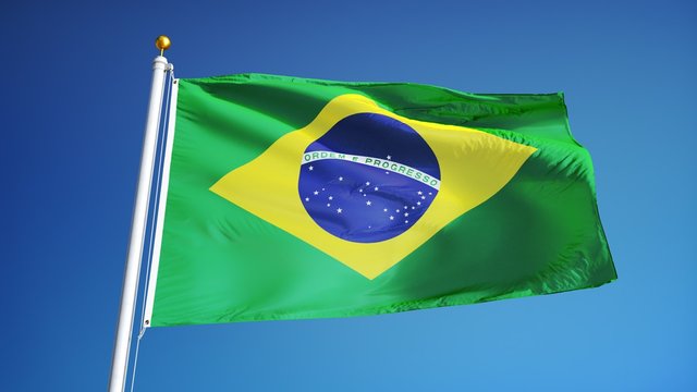 Brazil flag waving in slow motion against clean blue sky, seamlessly looped, close up, isolated on alpha channel with black and white luminance matte, perfect for film, news, digital composition
