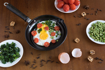 Fried eggs with tomatoes and green peas