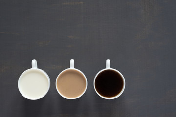 Three cups with coffee and milk
