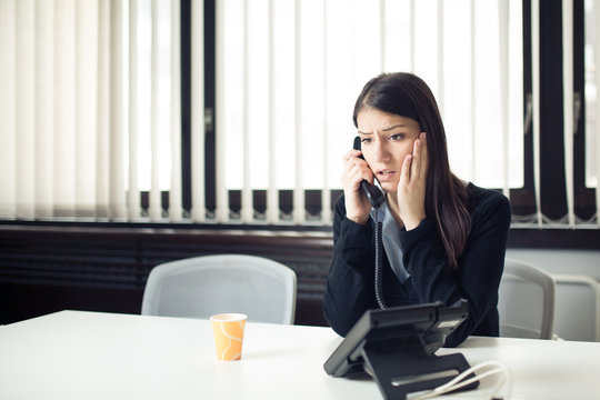 Worried stressed depressed office worker business woman receiving bad news emergency phone call at work.Looking confused and disappointed.Dismissed manager woman sitting in office.Getting fired.Argue