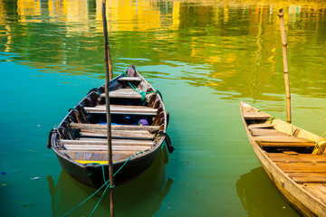 Fototapeta premium Traditional boats in front of ancient architecture in Hoi An, Vietnam. Hoi An is the World's Cultural heritage site, famous for mixed cultures & architecture.