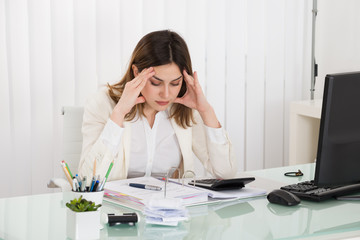 Depressed Businesswoman Calculating Invoice