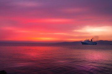 sunset with cruise ship  at twilight on Aegean sea, Greece