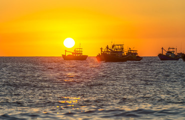 Naklejka premium Sunset over the sea as the sun pier horizon rounded bottom makes sunset boat with yellow sky it's great to watch
