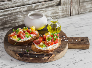 Tomato and cheese bruschetta on a rustic wooden cutting board. Healthy breakfast, snack or appetizer with wine
