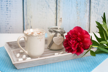 A tray with heated chocolate, sugar and red flower of peony