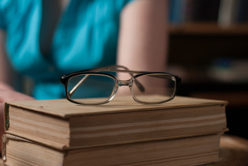 young girl in glasses reading a book