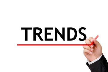 Trends word and hand holding pen on white background