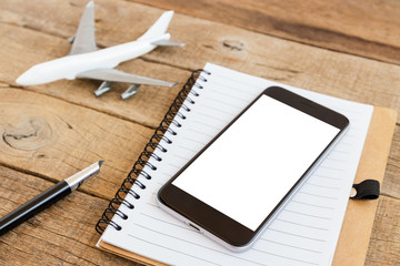 phone blank screen and airplane model on wood table