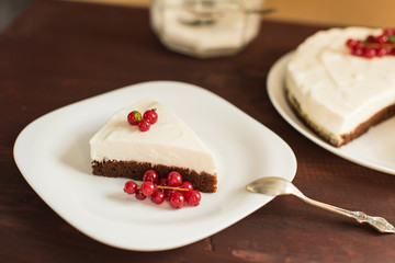 yoghurt cheesecake with fresh red currants on wooden table