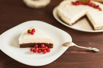 yoghurt cheesecake with fresh red currants on wooden table