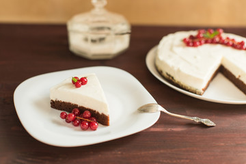 yoghurt cheesecake with fresh red currants on wooden table