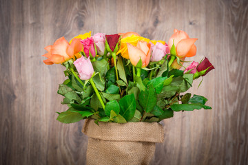 Roses in the sack on wooden background