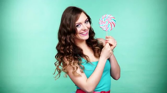 Woman smiling girl with lollipop candy on green 4K