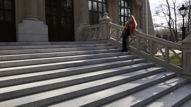 Portrait of a young teenage girl sitting on the front stairs of the old building