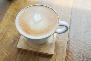 Hot latte coffee in glass  cup mug on wooden table