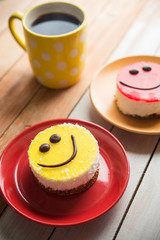 Coffee red cup and smile cake on wood table
