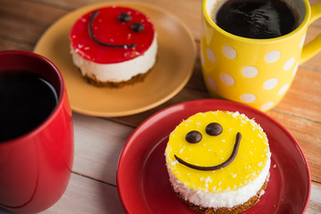 Coffee red cup and smile cake on wood table