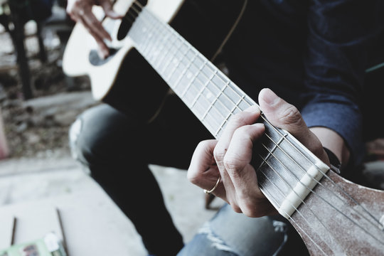 hand of man playing old classic guitar, vintage tones.