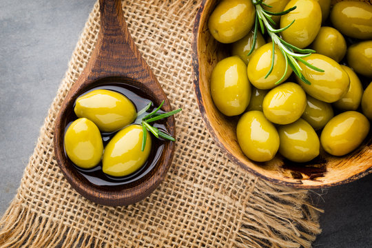 Fresh olives and gray background. Olives in bowl and spoon.