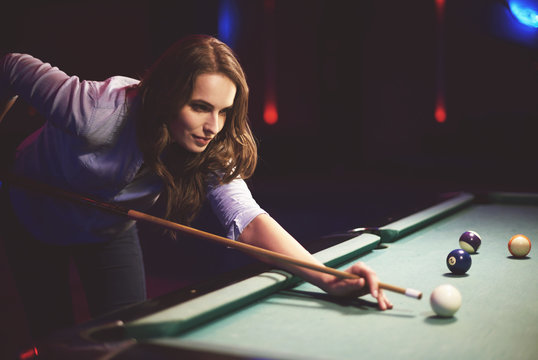 Woman playing pool game in the entertainment club