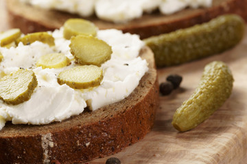 sandwiches with rye bread, cream cheese and marinated cucumbers, vintage toned