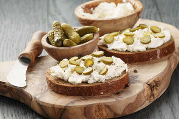 sandwiches with rye bread, cream cheese and marinated cucumbers, vintage toned